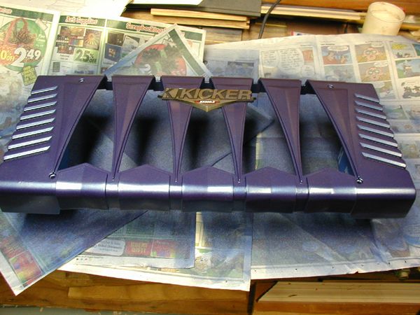 Purple Kicker amplifier cover with silver accents, sitting on newspapers