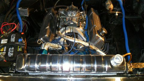 1954 Ford Crestline - The engine bay features a V8 engine, chrome radiator, and dual batteries, with blue hoses visible.