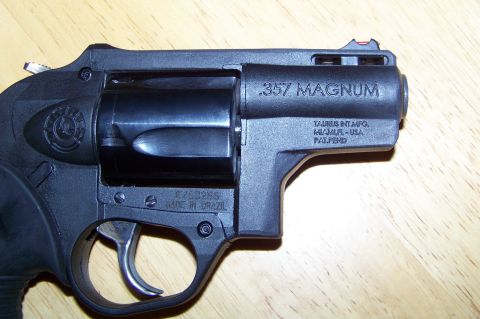 1994 Ford F-150 - Close-up of a black Taurus .357 Magnum revolver with visible markings and serial number.