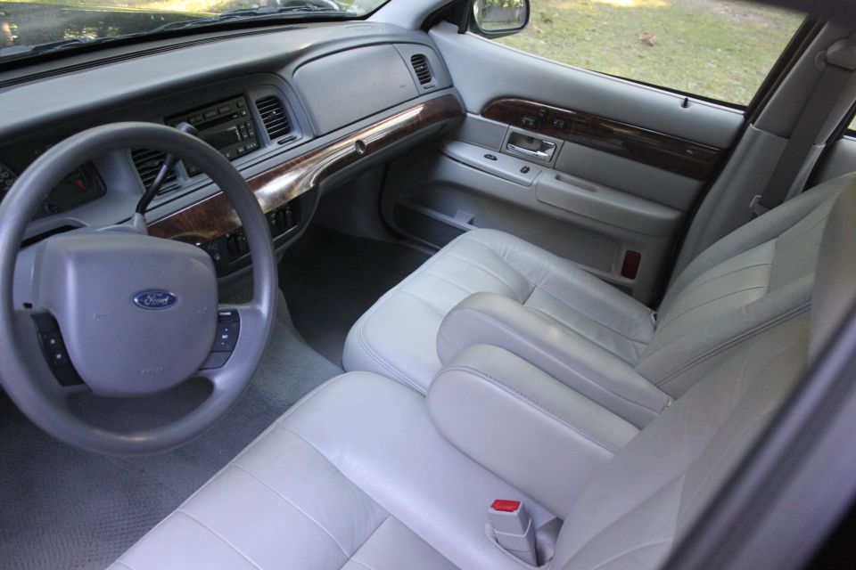 Gray leather interior of a Ford sedan showing dash, steering wheel, and front bench seat