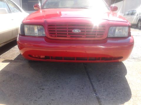 1999 Ford Crown Victoria - Front view of a red 1998 Ford Crown Victoria, its distinctive grille and Ford emblem.