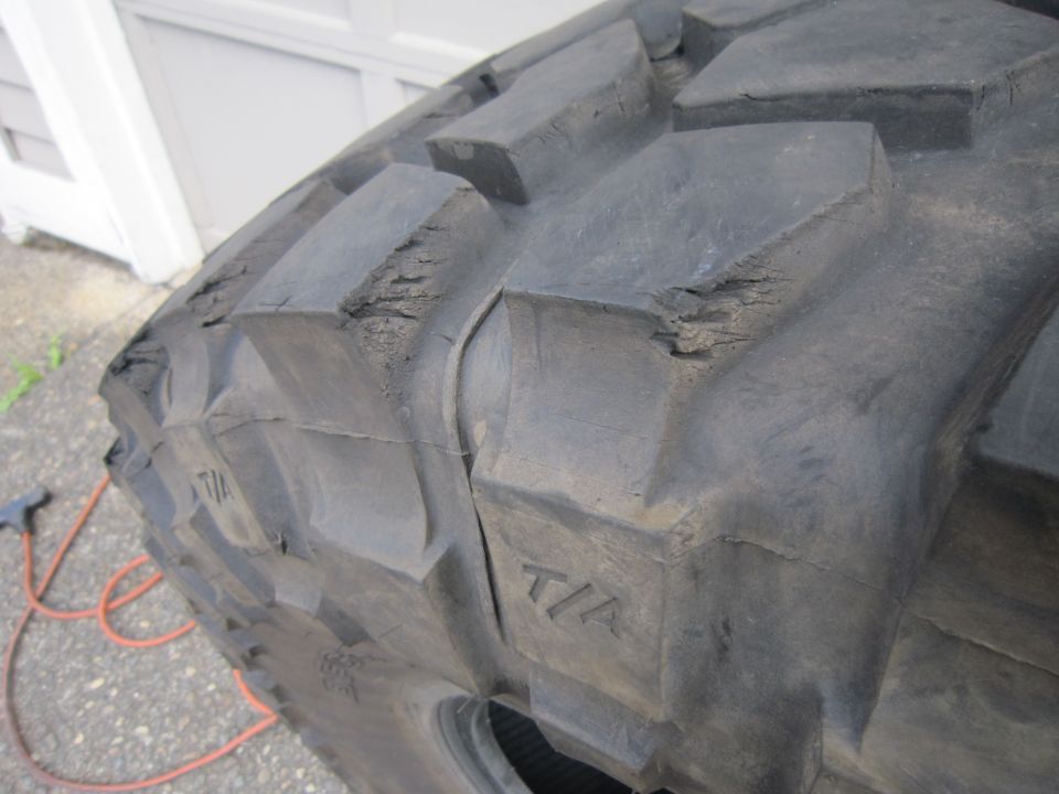 close-up of a worn tire with T/A markings and cracked tread blocks