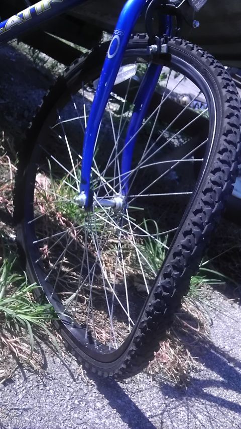 1989 Ford Bronco - A close-up view of a bicycle's front wheel and fork, showing damage to the wheel.