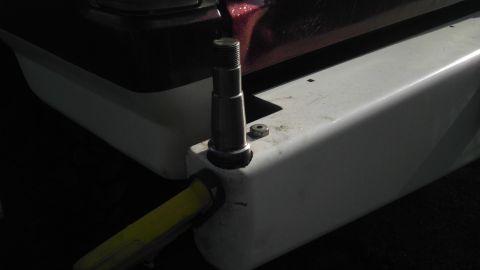 1989 Ford Bronco - Close-up of a metal post protruding from a white vehicle bumper with a yellow strap attached.