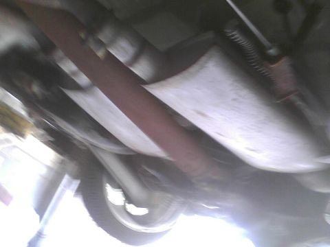 2003 Ford Crown Victoria - Underside view of a vehicle's exhaust system and suspension components.