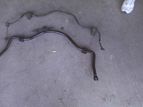 2003 Ford Crown Victoria - Two automotive sway bars are shown laid out on a concrete floor.