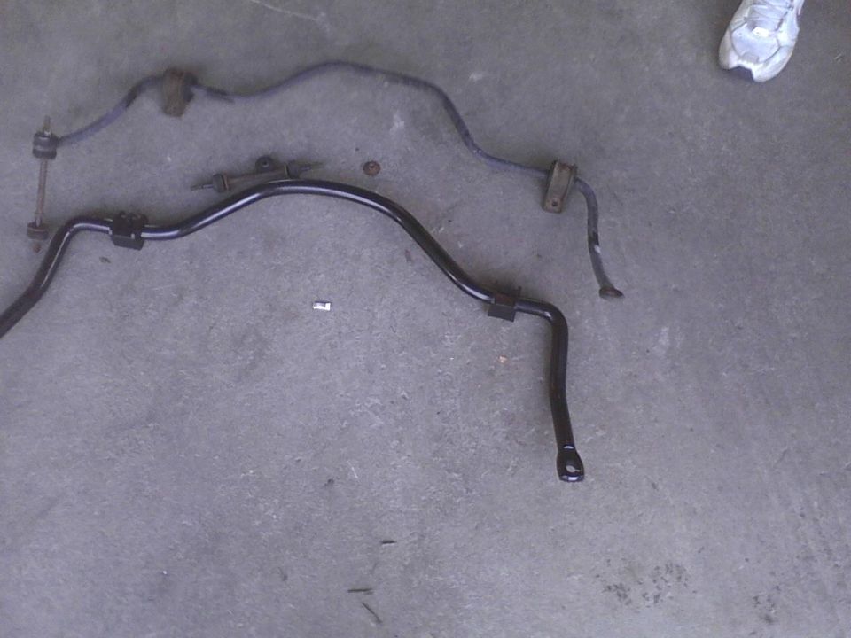 Two black sway bars on a concrete surface