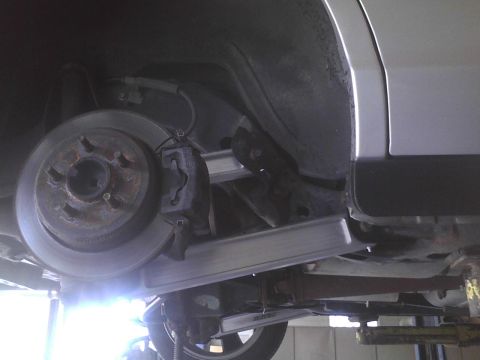 2003 Ford Crown Victoria - Close-up of a car's rear brake system, showing the rotor and caliper.