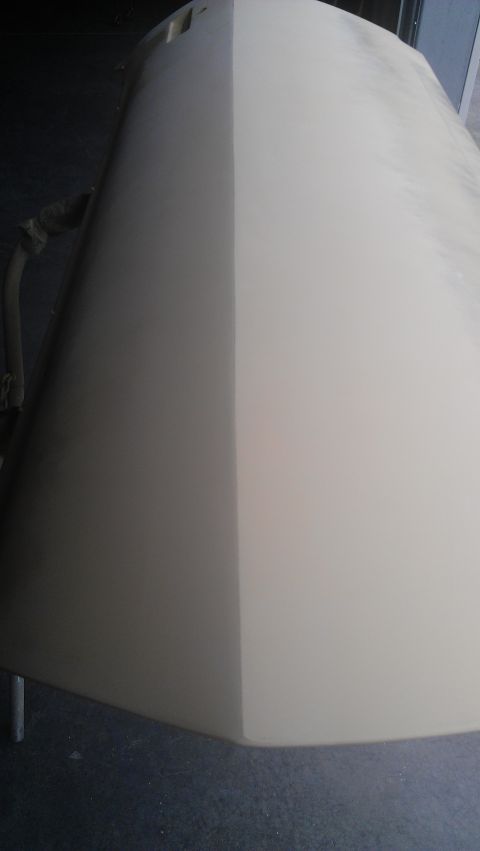 1973 Chevrolet Camaro - A car hood is shown with one half in primer and the other half painted, resting on sawhorses.