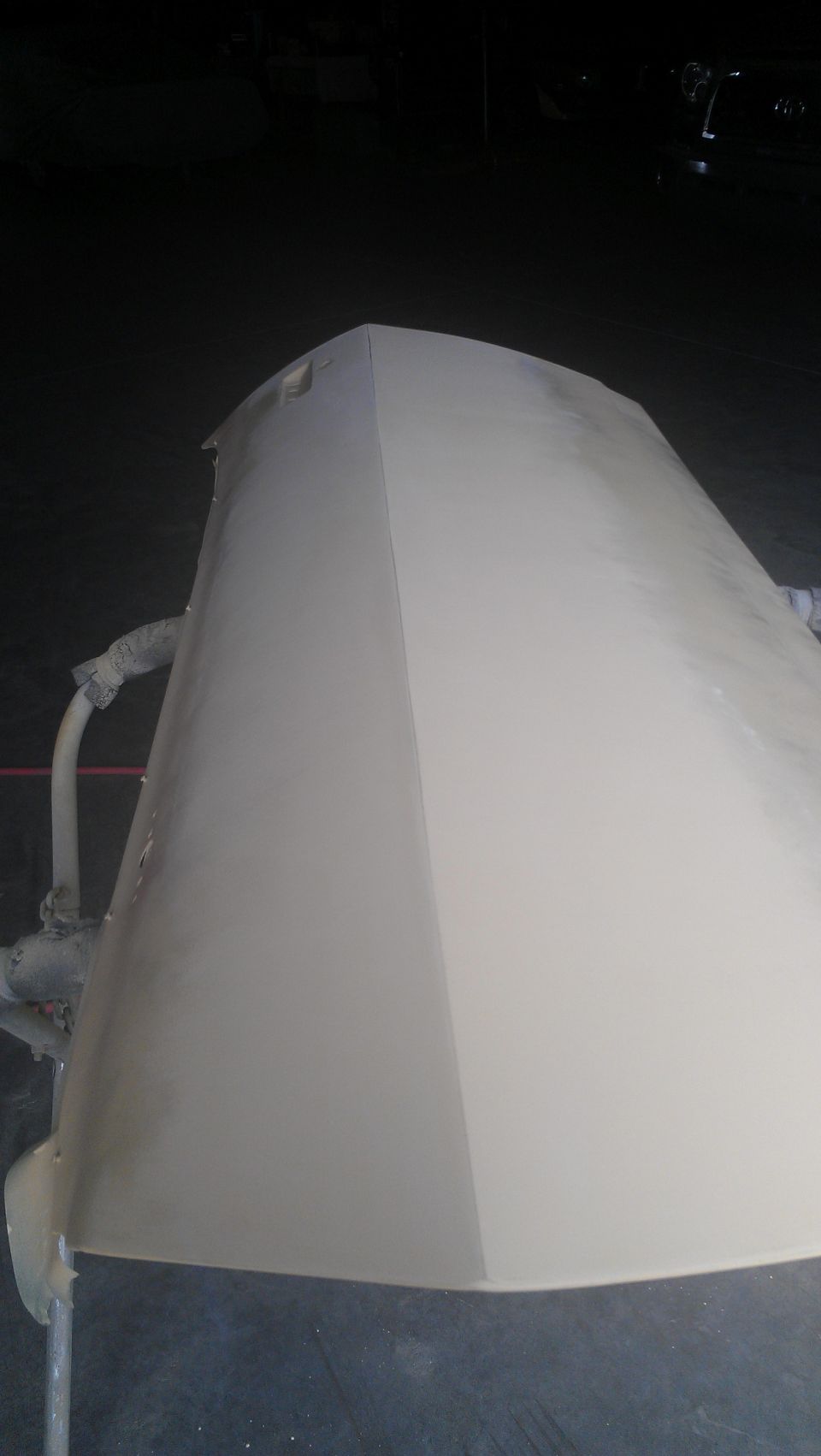 Car hood covered in primer, viewed from a high angle