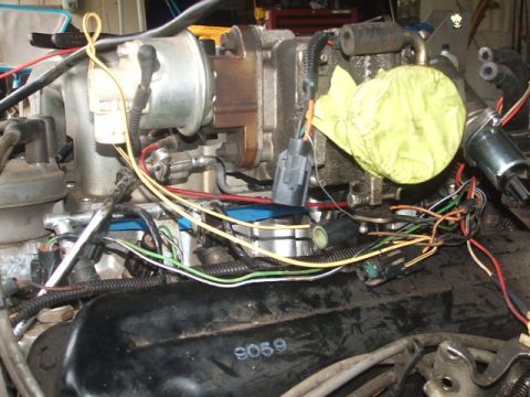 1966 Ford Ranchero - Close-up view of engine components and a complex wiring harness, with some parts covered by yellow tape.