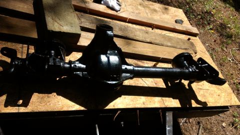 1978 Ford Bronco - A black painted differential axle rests on wooden planks, likely awaiting installation or restoration.