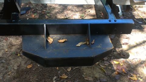 1978 Ford Bronco - A close-up view of a vehicle's frame, showing structural components and some fallen leaves.