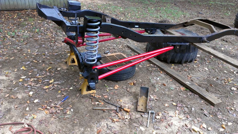 Vehicle frame with red suspension components on jack stands