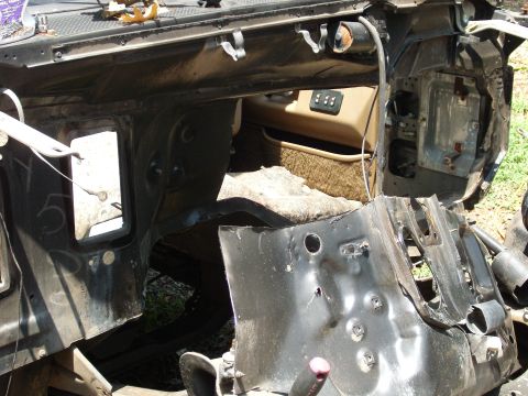 1988 Ford Bronco - Interior view of a damaged vehicle's firewall and dashboard, revealing exposed metal and wiring.