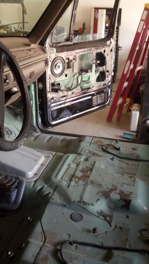 1995 Ford Bronco - The interior of a vehicle is shown with the door panel removed, revealing the speaker and wiring components.