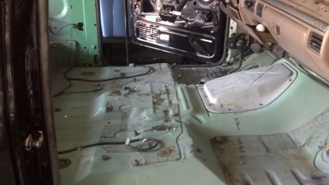 1995 Ford Bronco - The interior of the vehicle has been stripped down, revealing the floor pan and exposed wiring for repair or restoration.