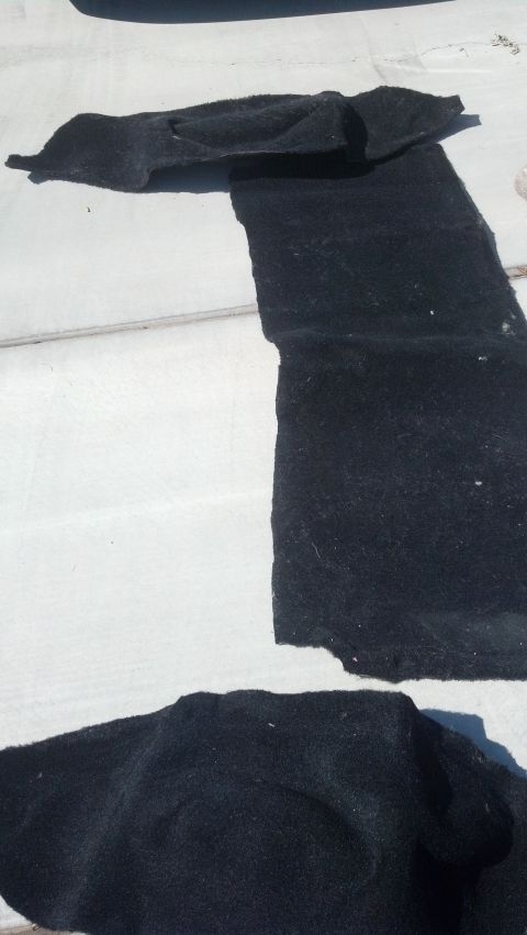 1995 Ford Bronco - Several black carpeted floor mats are spread out on a white surface, possibly for cleaning or replacement.