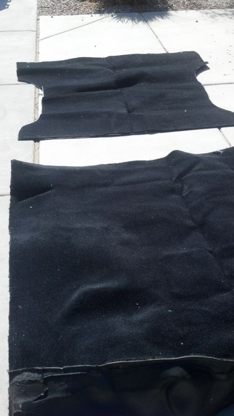 1995 Ford Bronco - Two black car floor mats are displayed on a concrete patio.