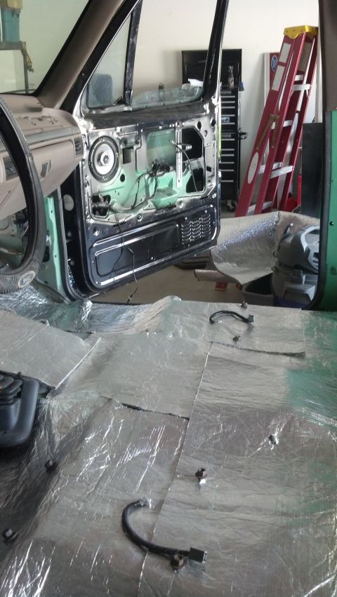 1995 Ford Bronco - The interior of a Ford Bronco is shown with the door panel removed and sound deadening material on the floor.