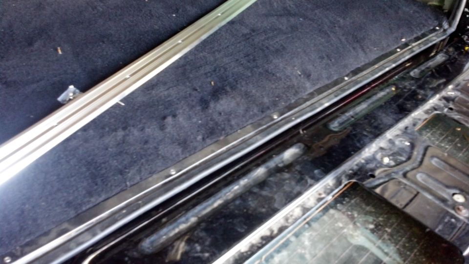 1995 Ford Bronco interior cargo area with black carpet and metal trim