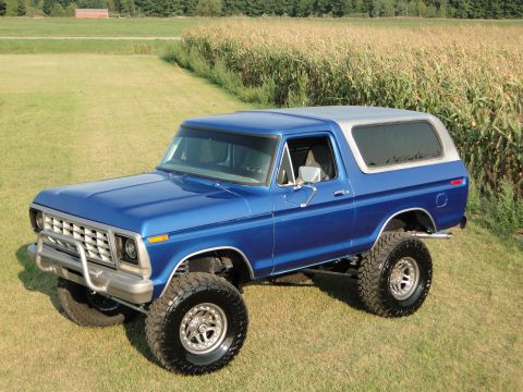 1978 Ford Bronco - This lifted 1978 Ford Bronco, painted in a vibrant blue with a contrasting silver roof, sits ready for adventure.
