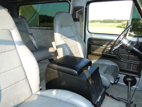 1978 Ford Bronco - The interior of a 1978 Ford Bronco features grey bucket seats and a prominent black center console.