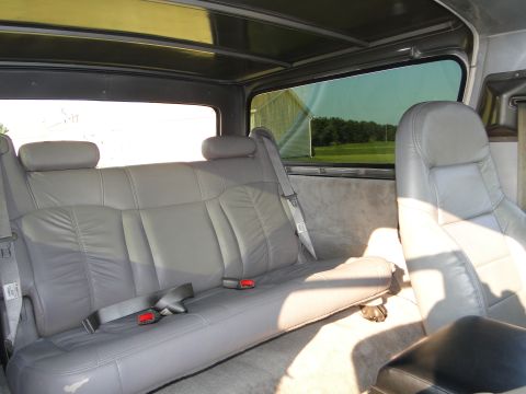 1978 Ford Bronco - Interior view of a vehicle's rear seating area with leather upholstery and tinted windows.