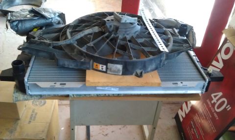 1993 Ford Bronco - Radiator and fan assembly, likely for a vehicle, resting on a table.