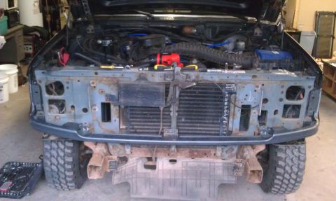 1993 Ford Bronco - The front end of a Ford truck is disassembled, revealing the engine and radiator components.