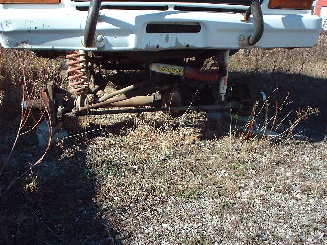 Front suspension and bumper of a white vehicle with "Hellmaster" shocks visible