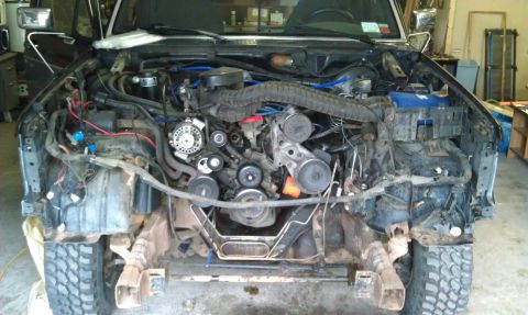 1993 Ford Bronco - The front end of a 1993 Ford Bronco is disassembled, revealing the engine and associated components.