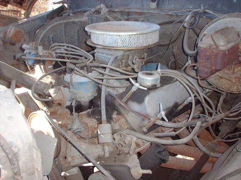 1993 Ford Bronco - The engine bay shows a distributor, air cleaner, and exhaust manifold with visible rust and wiring.