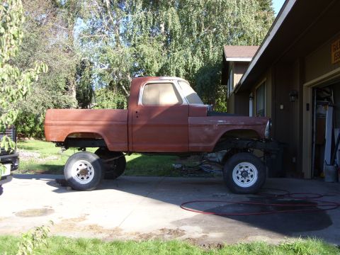 1967 Ford F-250 - This 1967 Ford F-250 pickup truck is shown in profile, a lifted suspension and a red, unfinished body.