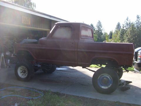 1967 Ford F-250 - This 1967 Ford F-250 pickup truck is shown in primer, lifted with large tires, and appears to be undergoing restoration.