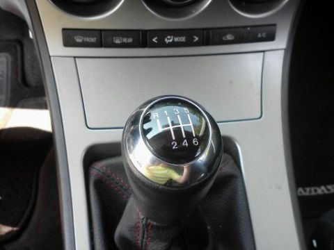 2010 Mazda 3 - Interior view of a Mazda 3 showing the gear shifter and dashboard controls.