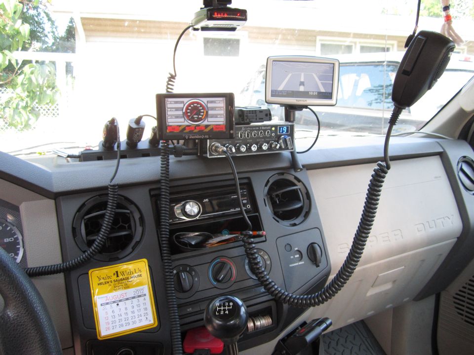 Dashboard of a Ford Super Duty truck with a CB radio, Garmin GPS, radar detector, and a calendar showing August 2012