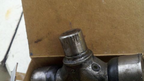 1978 Ford Bronco - A close-up view of a metal universal joint part, possibly for a vehicle, resting in a cardboard box.