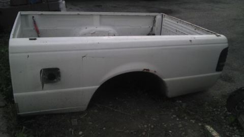 1987 Ford Ranger - A white pickup truck bed sits outdoors, showing signs of wear and rust.