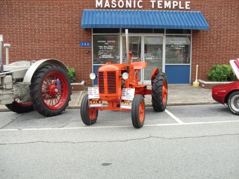 2012 Ford Bronco - Orange tractor and other vehicles parked outside a Masonic Temple building.