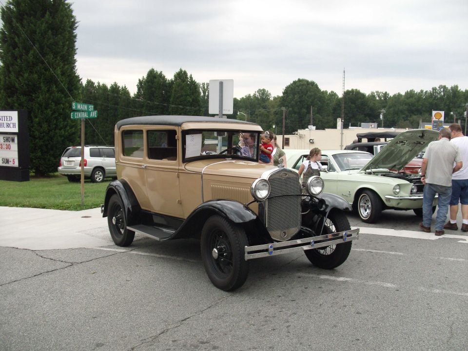 Tan and black sedan with black fenders and roof, seen from a 3/4 front angle
