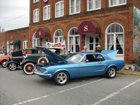 2012 Ford Bronco - A blue 1967 Ford Mustang coupe is displayed with its hood and trunk open, alongside other vintage vehicles.