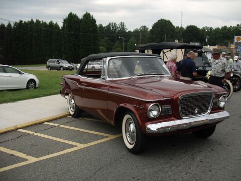 2012 Ford Bronco - A classic convertible is parked at an outdoor event with several people nearby and other vehicles visible.