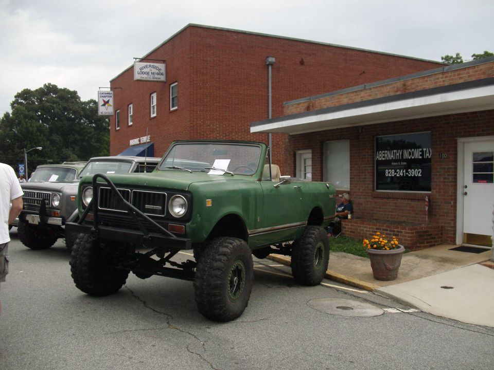Green convertible SUV with large tires and a brush guard