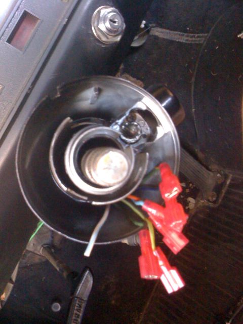 1964 Ford Ranchero - The steering column shroud is removed, exposing the ignition cylinder and wiring harness with red wire connectors.