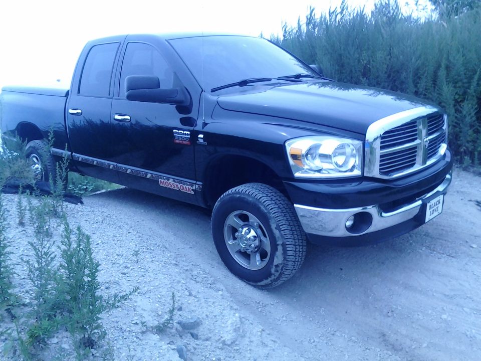 Black Dodge Ram 2500 pickup truck with Mossy Oak decals on the lower body