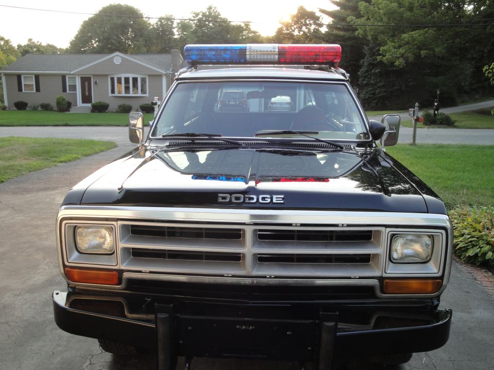 Black 1987 Dodge 1500 police truck front view with light bar on roof