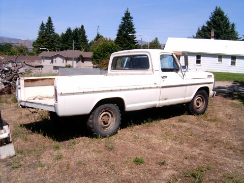 1967 Ford F-250 - This 1967 Ford F-250 pickup truck is parked in a grassy area with houses and trees in the background.