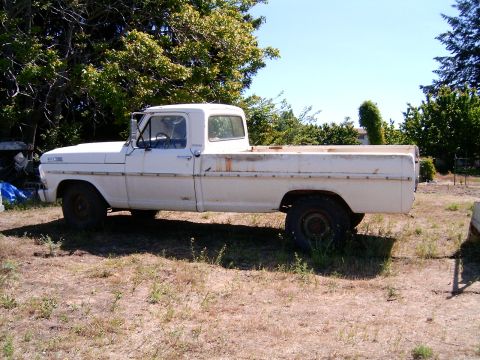 1967 Ford F-250 - This 1967 Ford F-250 pickup truck is parked in a grassy area with trees in the background.