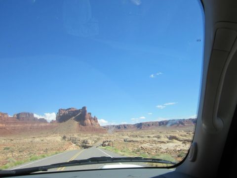 1991 Ford LTD Crown Victoria - Driving through a desert landscape with prominent rock formations and a vast blue sky.